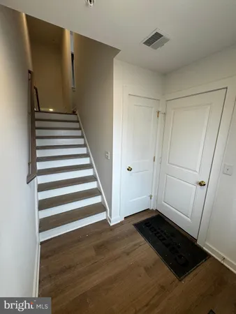 a view of a room with wooden floor and white walls
