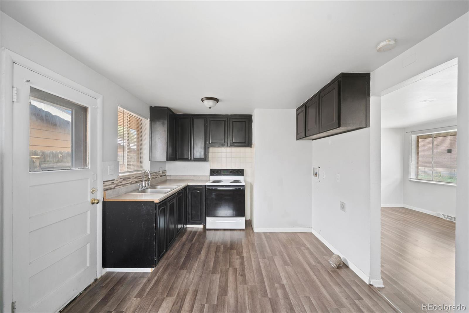 4785 Carr Street Wheat Ridge, CO 80033 - Photo 13 of 27 a view with kitchen island wooden floors and stainless steel appliances