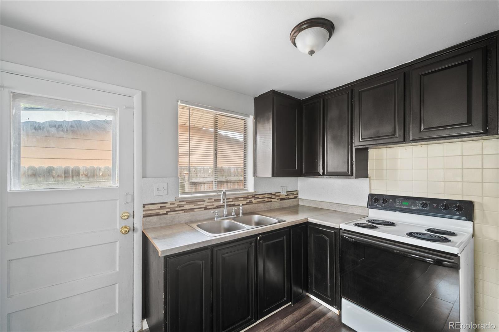 4785 Carr Street Wheat Ridge, CO 80033 - Photo 14 of 27 a kitchen with a sink stove and cabinets