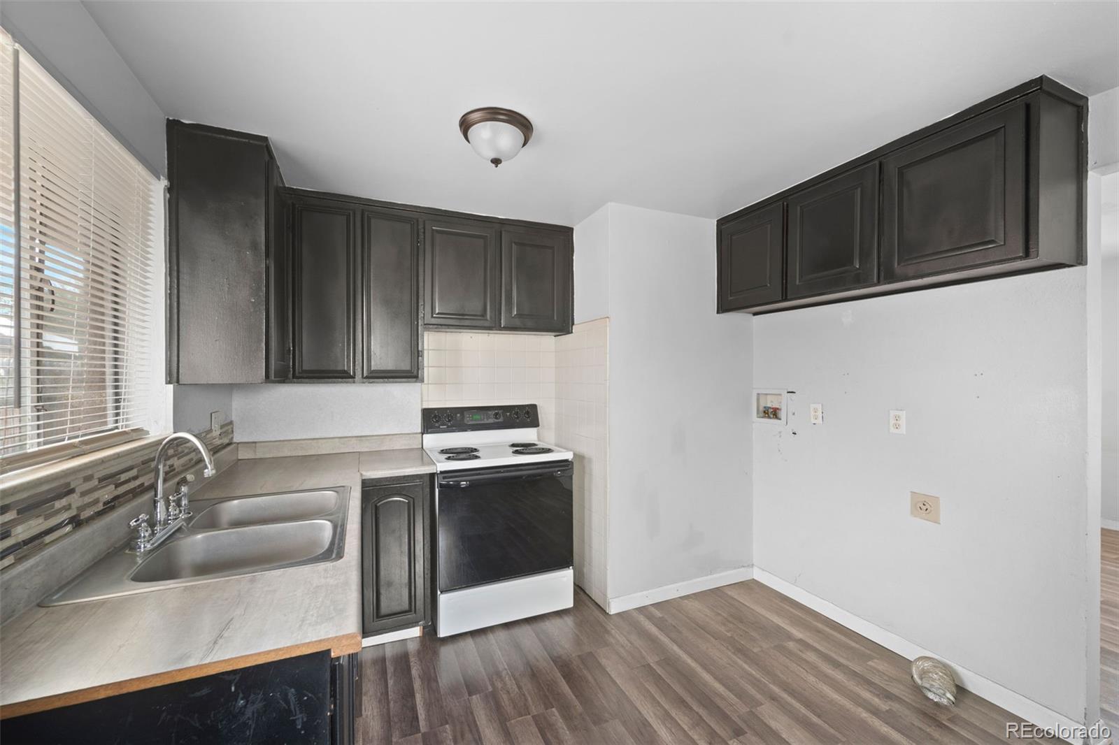 4785 Carr Street Wheat Ridge, CO 80033 - Photo 15 of 27 a kitchen with stainless steel appliances granite countertop a sink stove and microwave