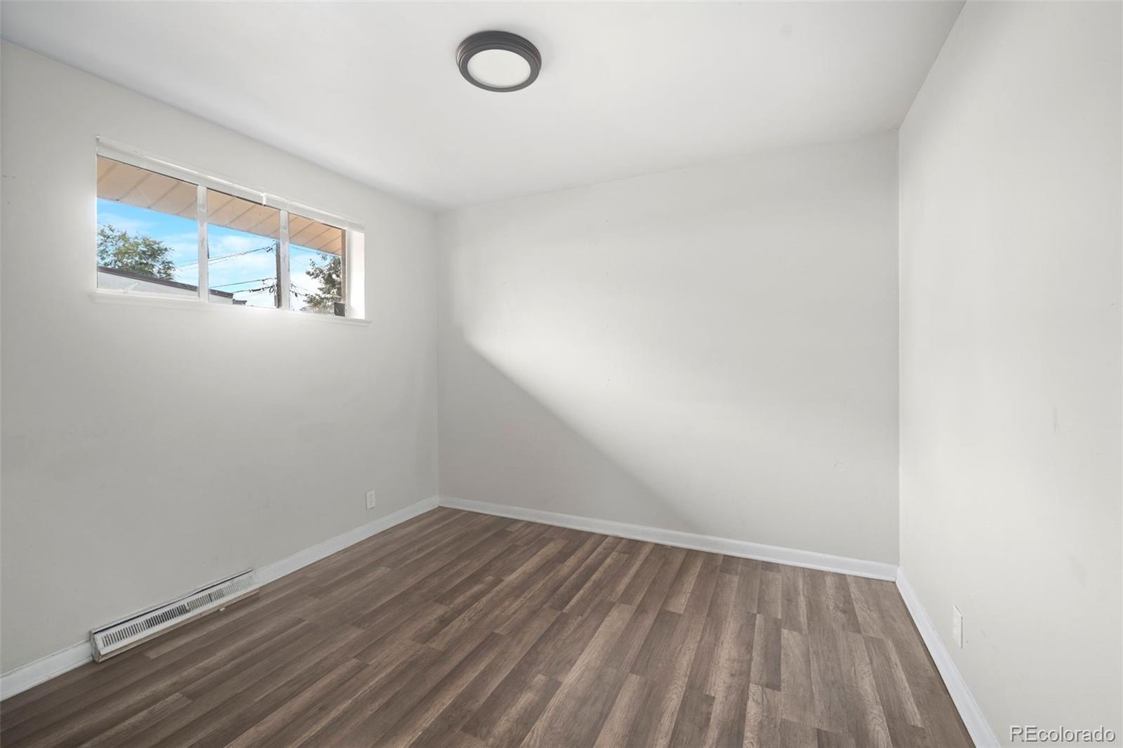 4785 Carr Street Wheat Ridge, CO 80033 - Photo 17 of 27 a view of a room with wooden floor and window