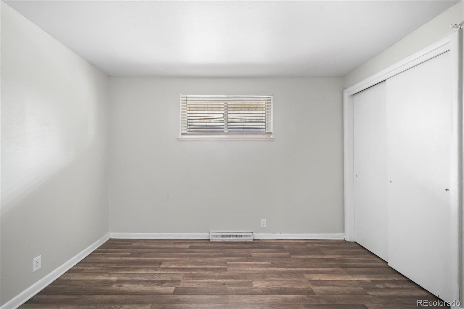 4785 Carr Street Wheat Ridge, CO 80033 - Photo 21 of 27 a view of an empty room with wooden floor and a window
