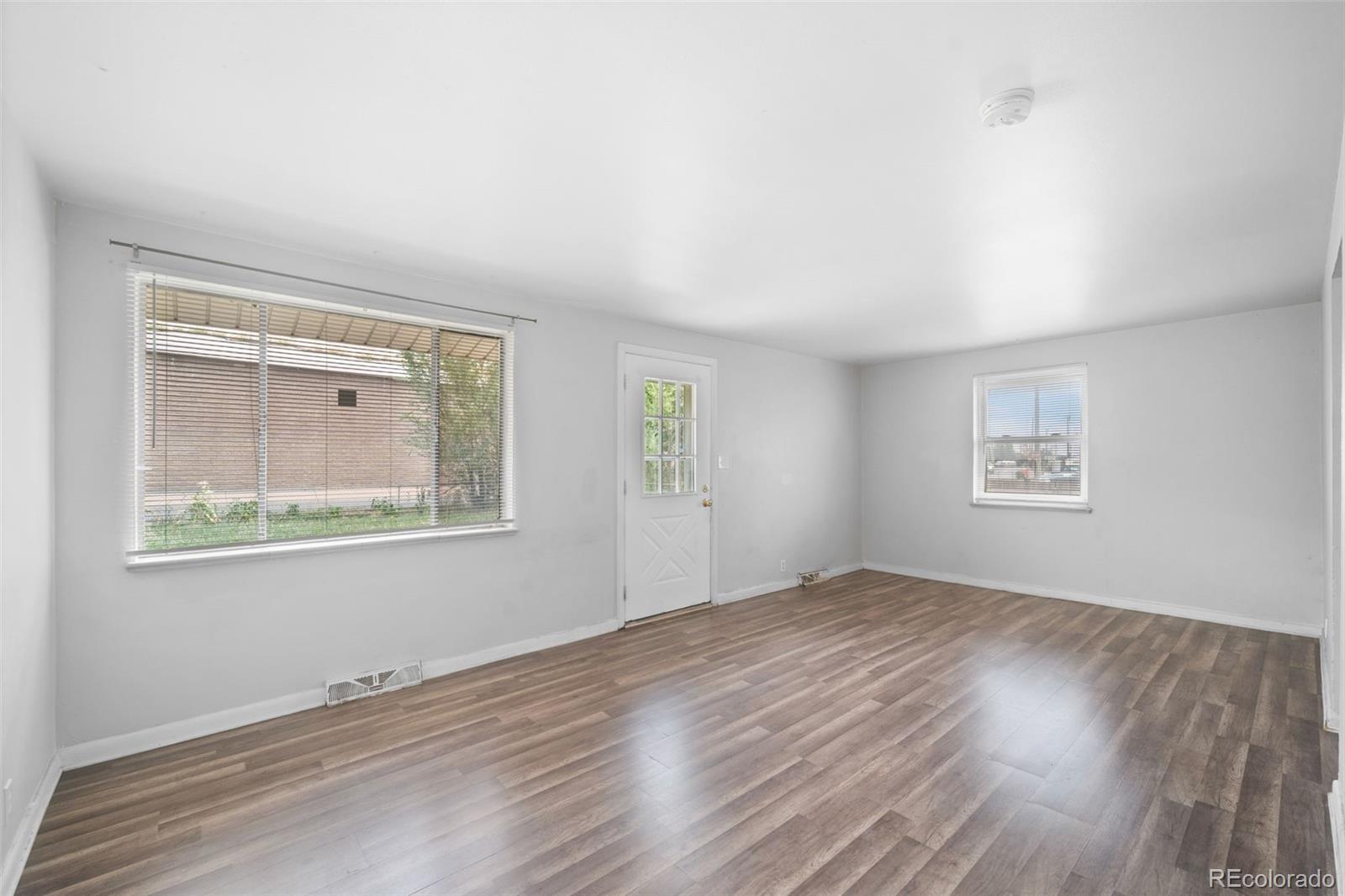 4785 Carr Street Wheat Ridge, CO 80033 - Photo 6 of 27 a view of an empty room with wooden floor and a window
