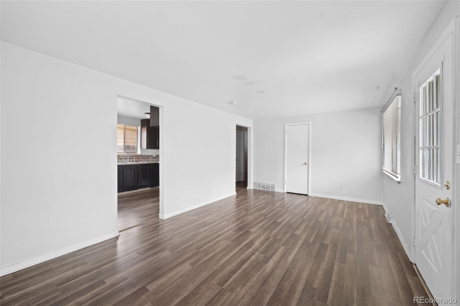 4785 Carr Street Wheat Ridge, CO 80033 - Photo 7 of 27 a view of an empty room with wooden floor and a window