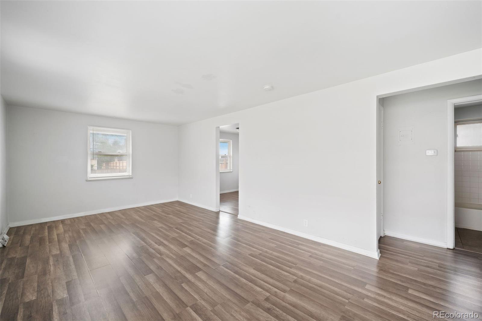 4785 Carr Street Wheat Ridge, CO 80033 - Photo 9 of 27 an empty room with wooden floor and windows