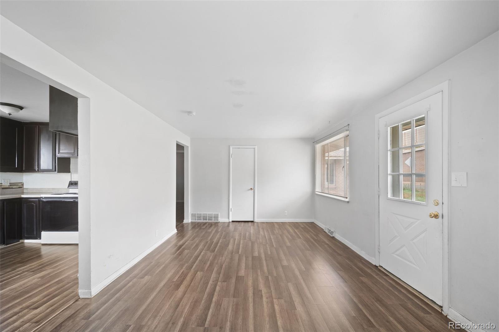4785 Carr Street Wheat Ridge, CO 80033 - Photo 10 of 27 a view of a room with wooden floor and a kitchen