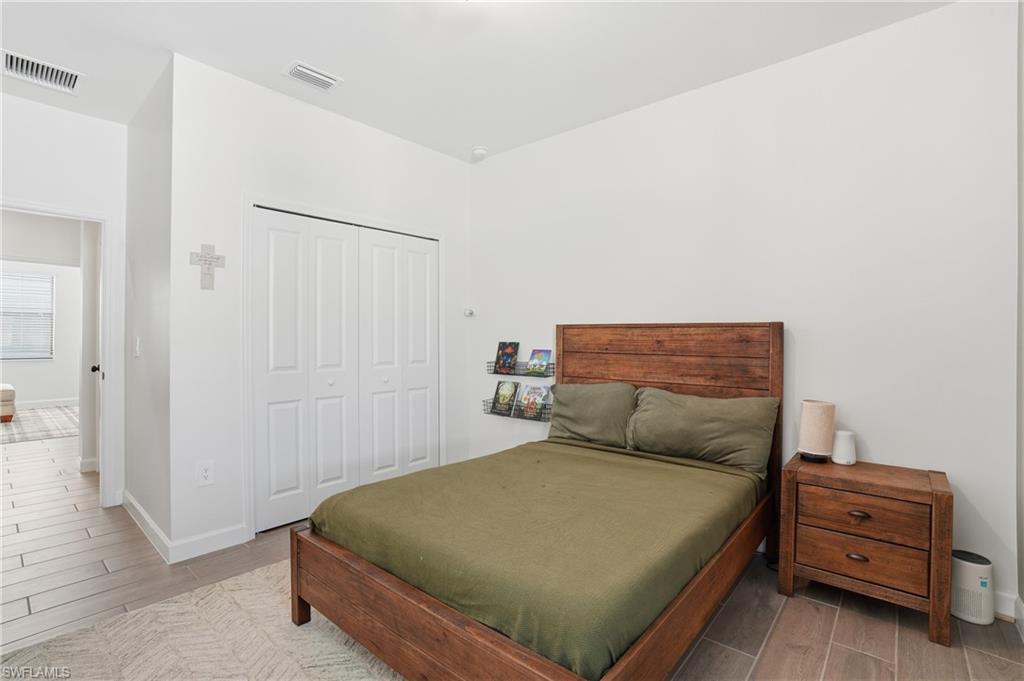 19306 Hinkley Drive Estero, FL 33928 - Photo 19 of 49 a bedroom with a bed and a cabinets