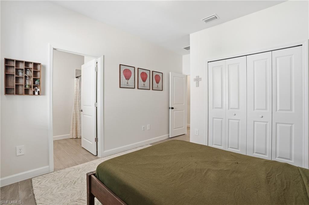 19306 Hinkley Drive Estero, FL 33928 - Photo 20 of 49 a bedroom with a bed and a book shelf