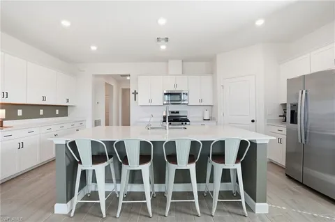 a kitchen with stainless steel appliances a stove a sink a refrigerator and cabinets