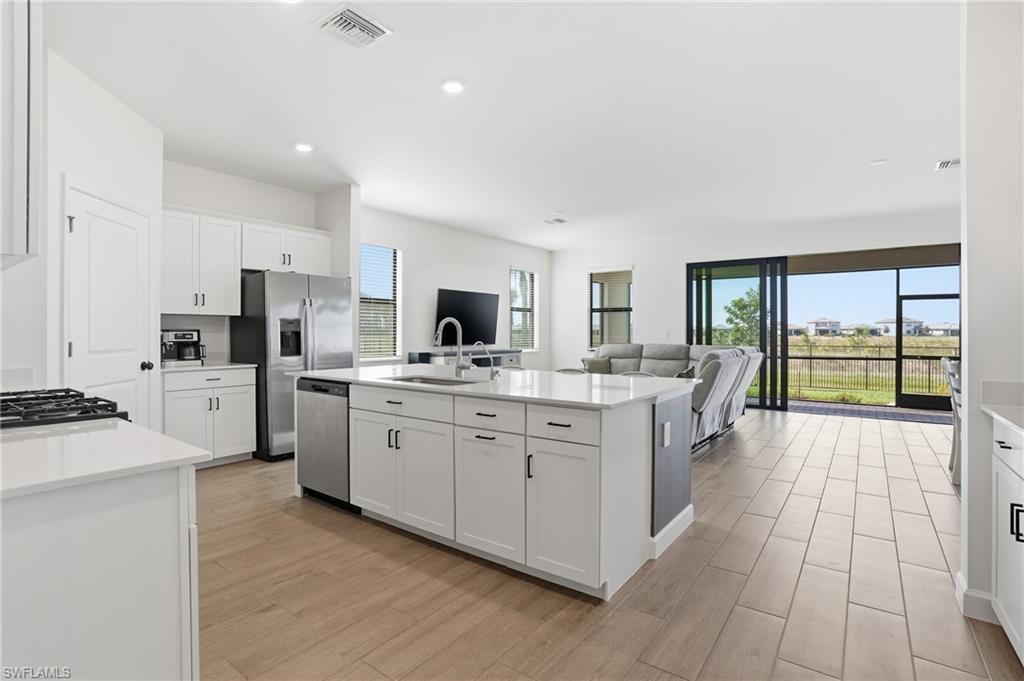 19306 Hinkley Drive Estero, FL 33928 - Photo 10 of 49 a large kitchen with a large window and stainless steel appliances