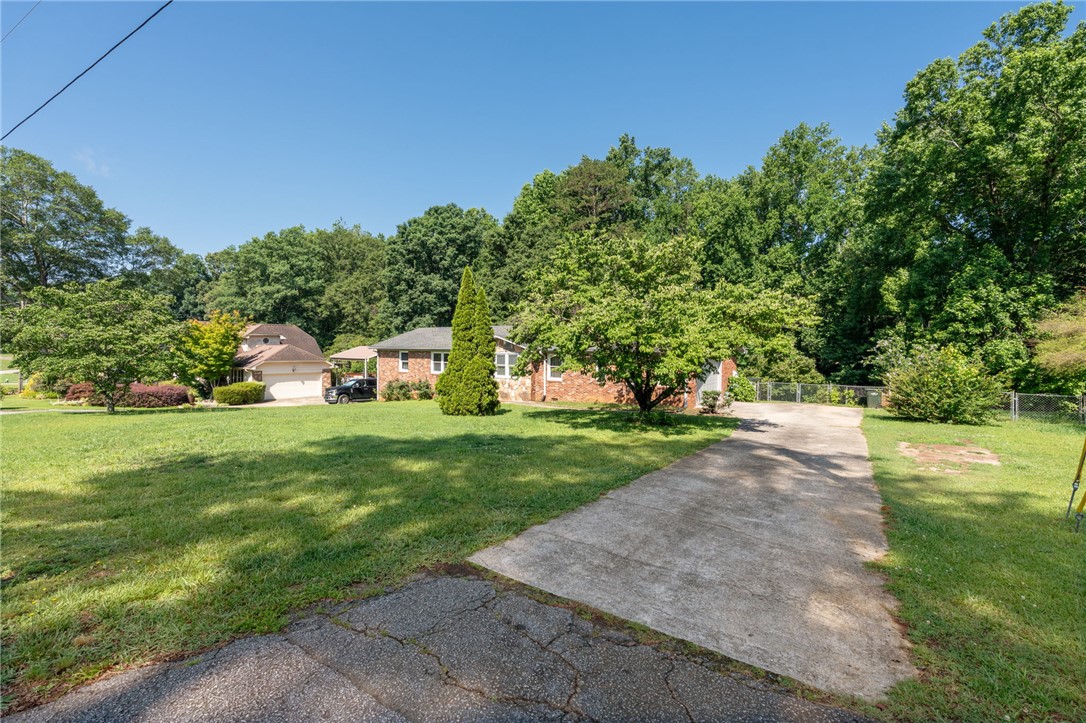 200 Echo Circle Easley, SC 29642 - Photo 33 of 35 Mature trees frame a charming brick residence, creating a private and verdant setting.