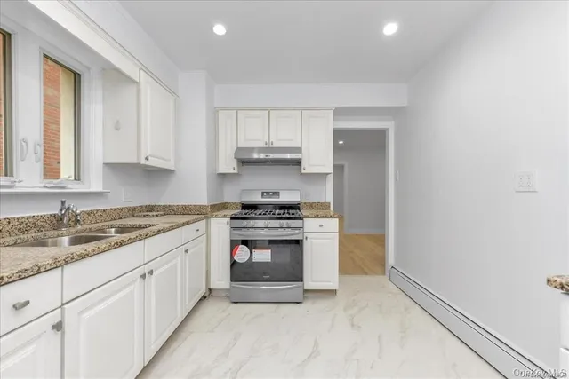 a kitchen with granite countertop a sink and a stove top oven