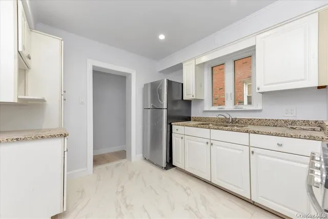 a kitchen with granite countertop a refrigerator and a sink