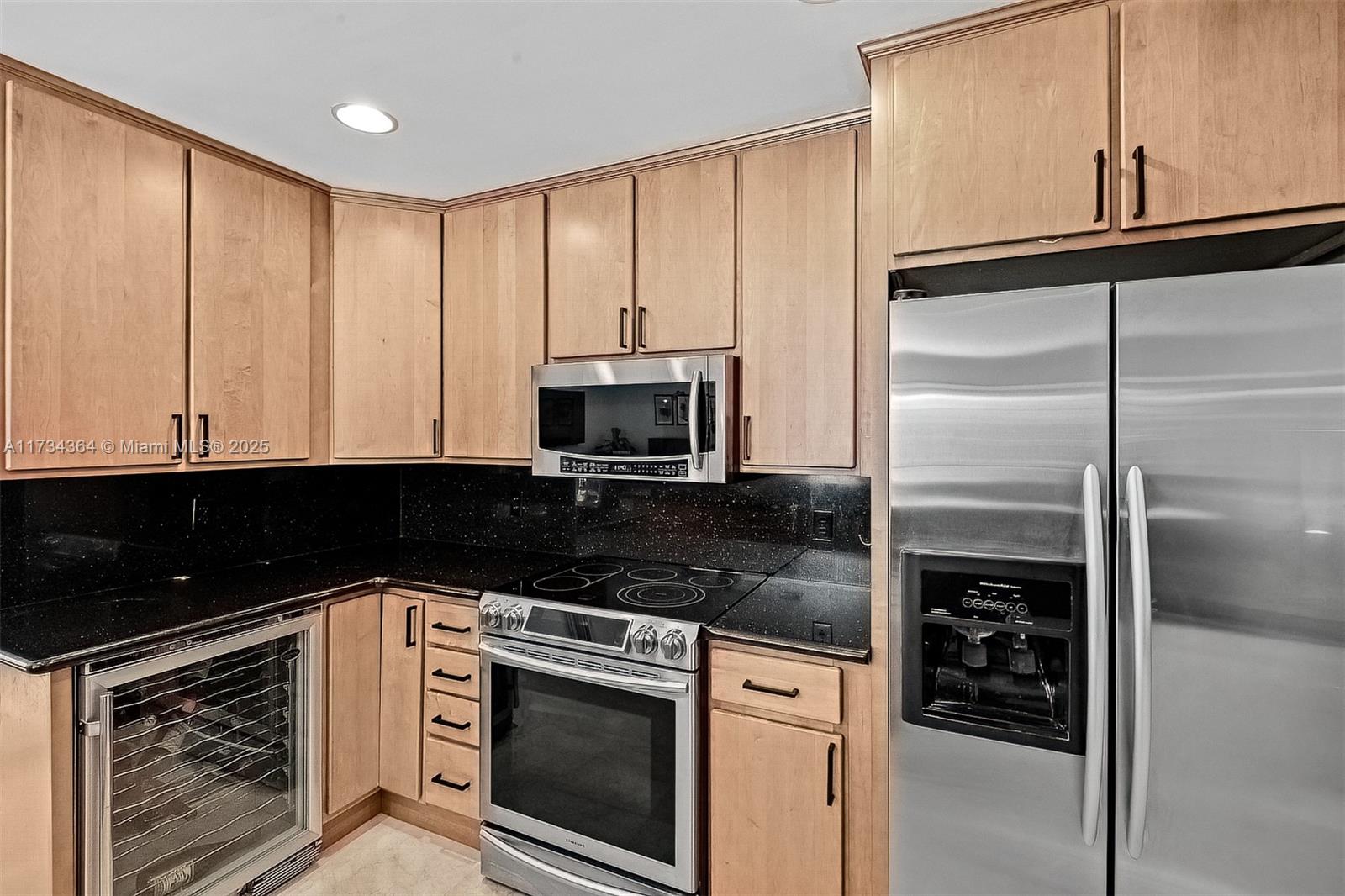 7260 Northwest 4th Avenue Boca Raton, FL 33487 - Photo 23 of 59 a kitchen with granite countertop white cabinets and stainless steel appliances