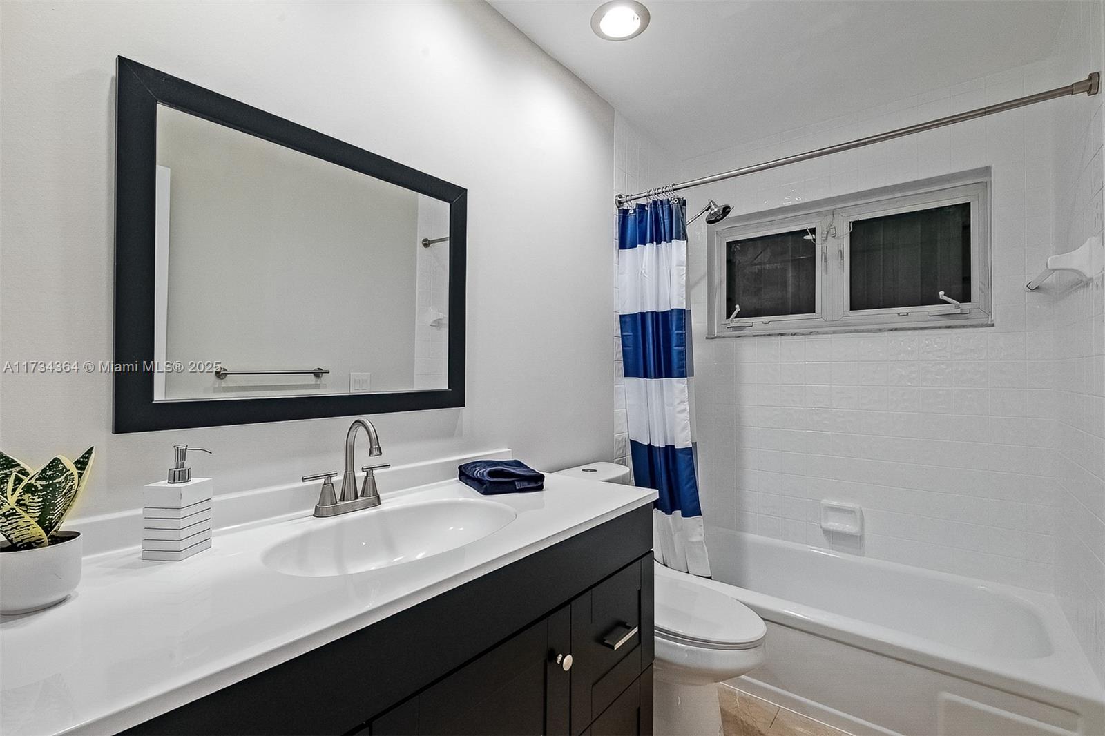 7260 Northwest 4th Avenue Boca Raton, FL 33487 - Photo 33 of 59 a bathroom with a toilet a sink a tub and mirror