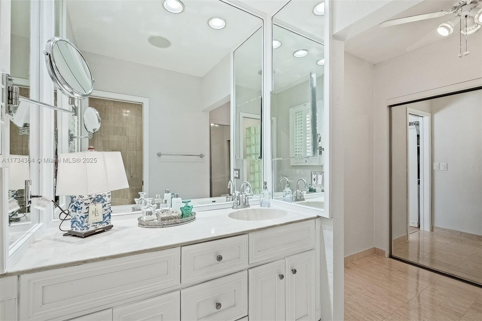 7260 Northwest 4th Avenue Boca Raton, FL 33487 - Photo 35 of 59 a bathroom with double vanity sinks a vanity two mirror and a shower