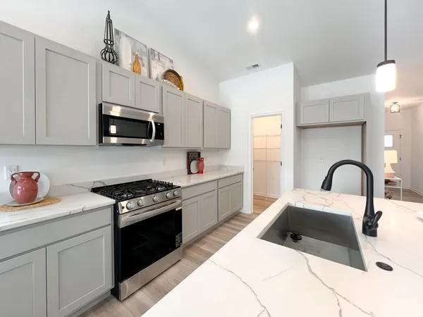 a kitchen with stainless steel appliances a stove a sink a microwave and cabinets