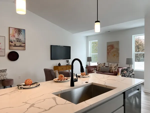 a kitchen with a sink a counter space and a dining room