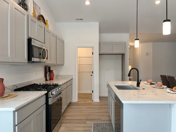 a kitchen with stainless steel appliances granite countertop a sink a stove and a refrigerator