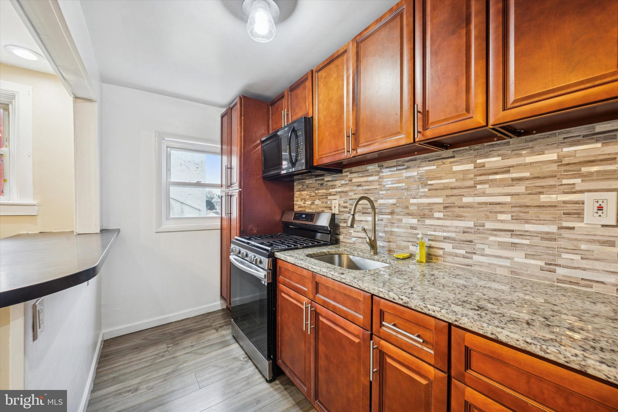 7162 Radbourne Road Upper Darby, PA 19082 - Photo 8 of 26 a kitchen with stainless steel appliances granite countertop a sink stove and cabinets