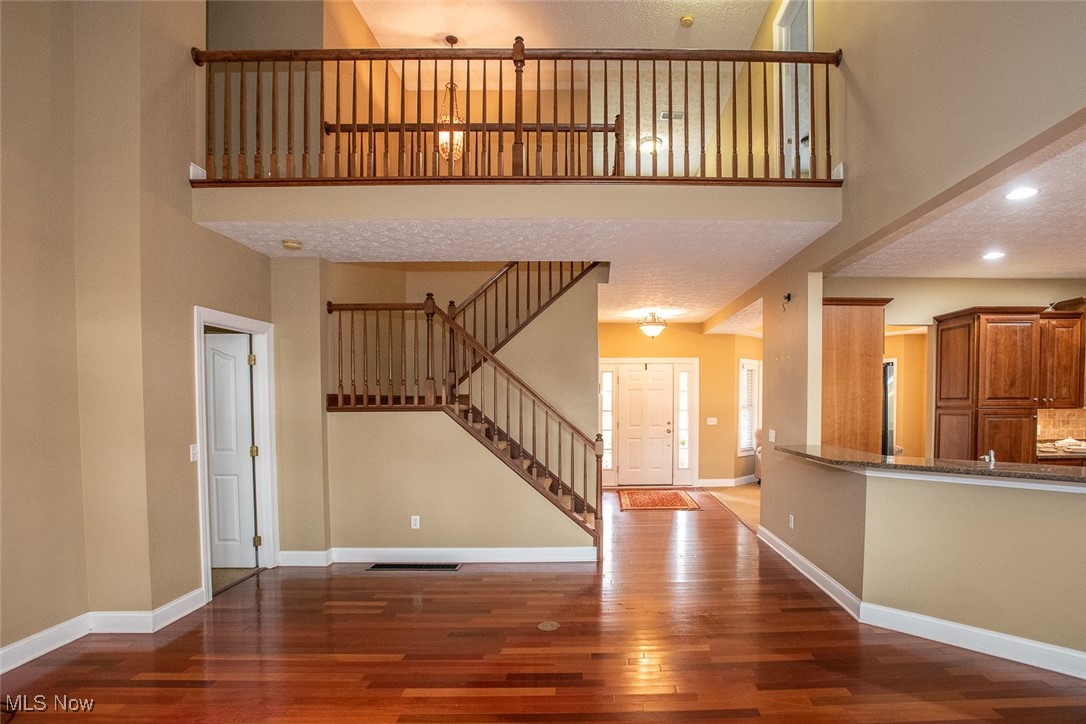 630 Rundle Street Lagrange, OH 44050 - Photo 42 of 49 Unfurnished living room featuring a high ceiling, stairway, and dark wood finished floors