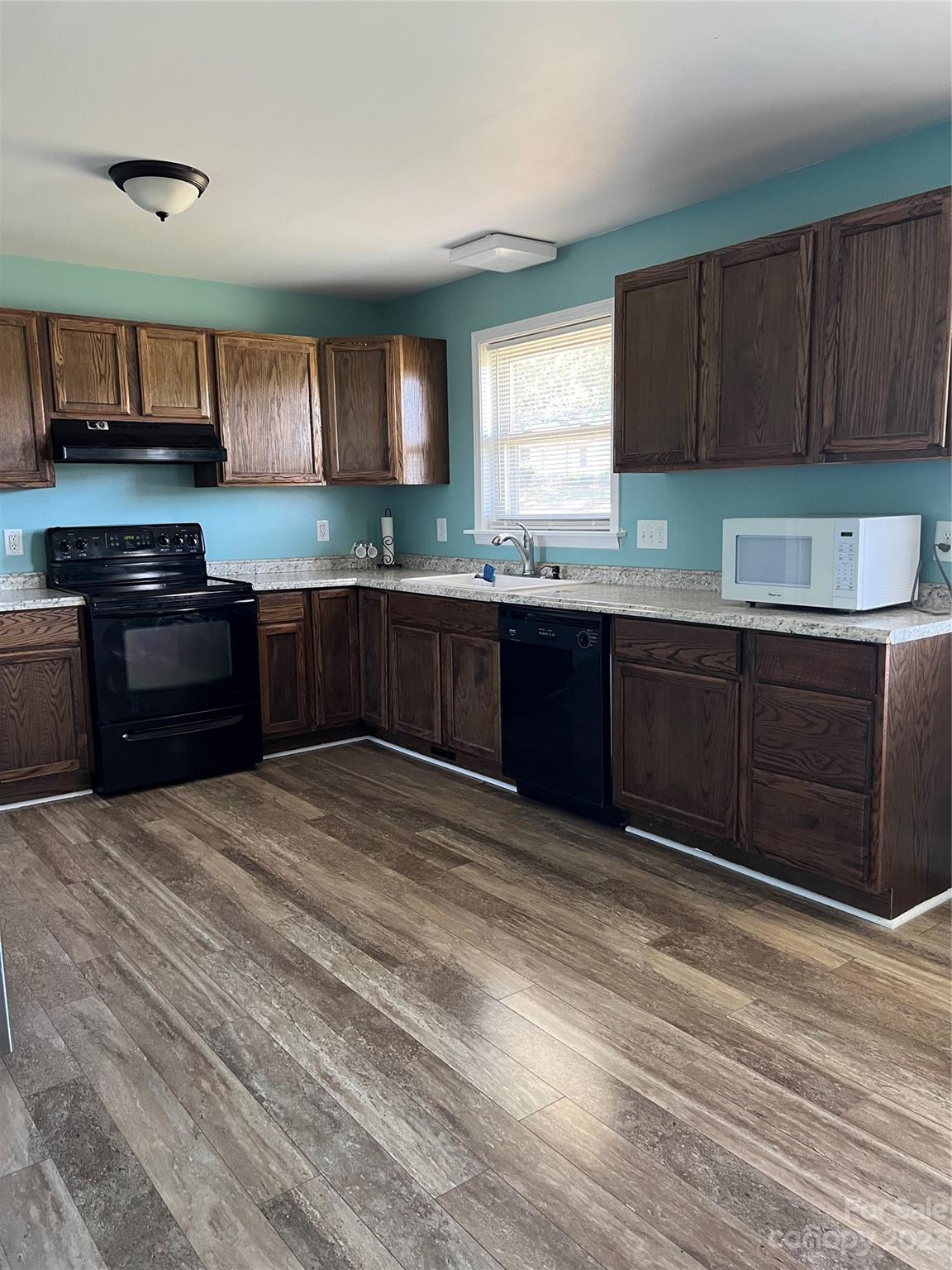 3018 East Brief Road Monroe, NC 28110 - Photo 4 of 11 a kitchen with stainless steel appliances granite countertop a stove a sink and a microwave