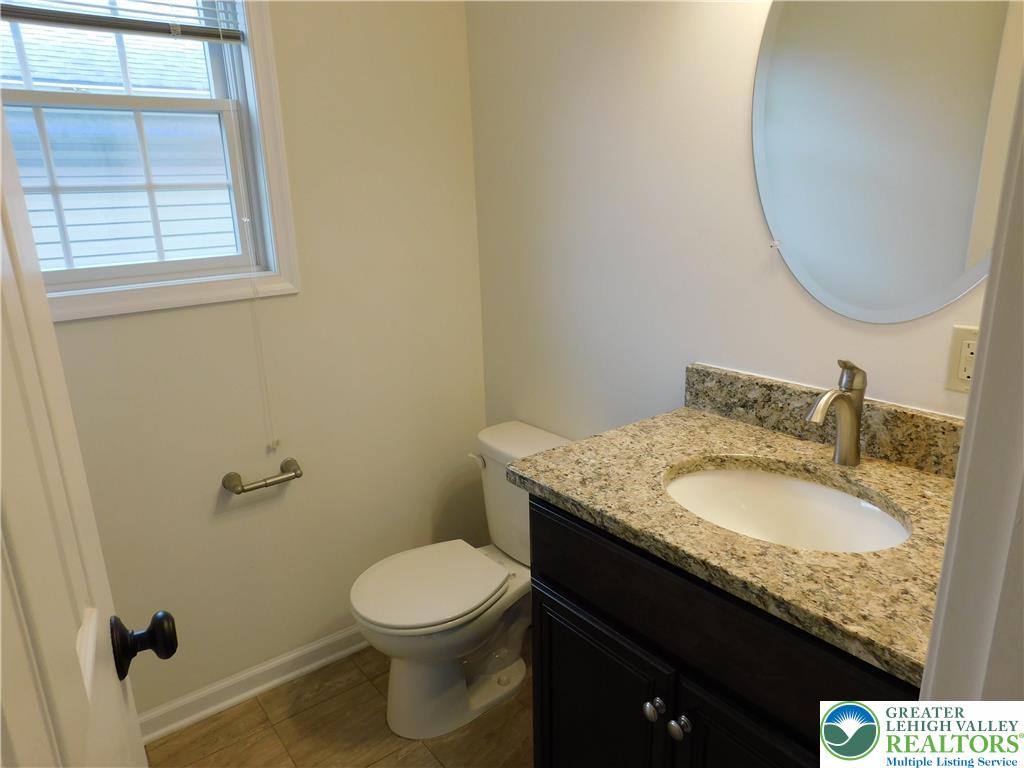 821 Masslich Street Bethlehem, PA 18018 - Photo 11 of 23 a bathroom with a granite countertop toilet a sink and a mirror
