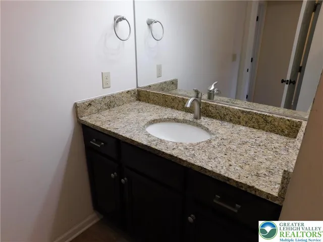 a bathroom with a granite countertop sink and a mirror