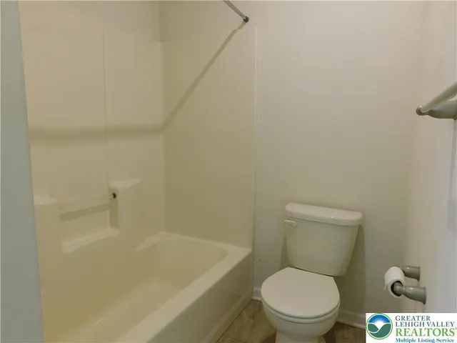 a white toilet sitting next to a bath tub