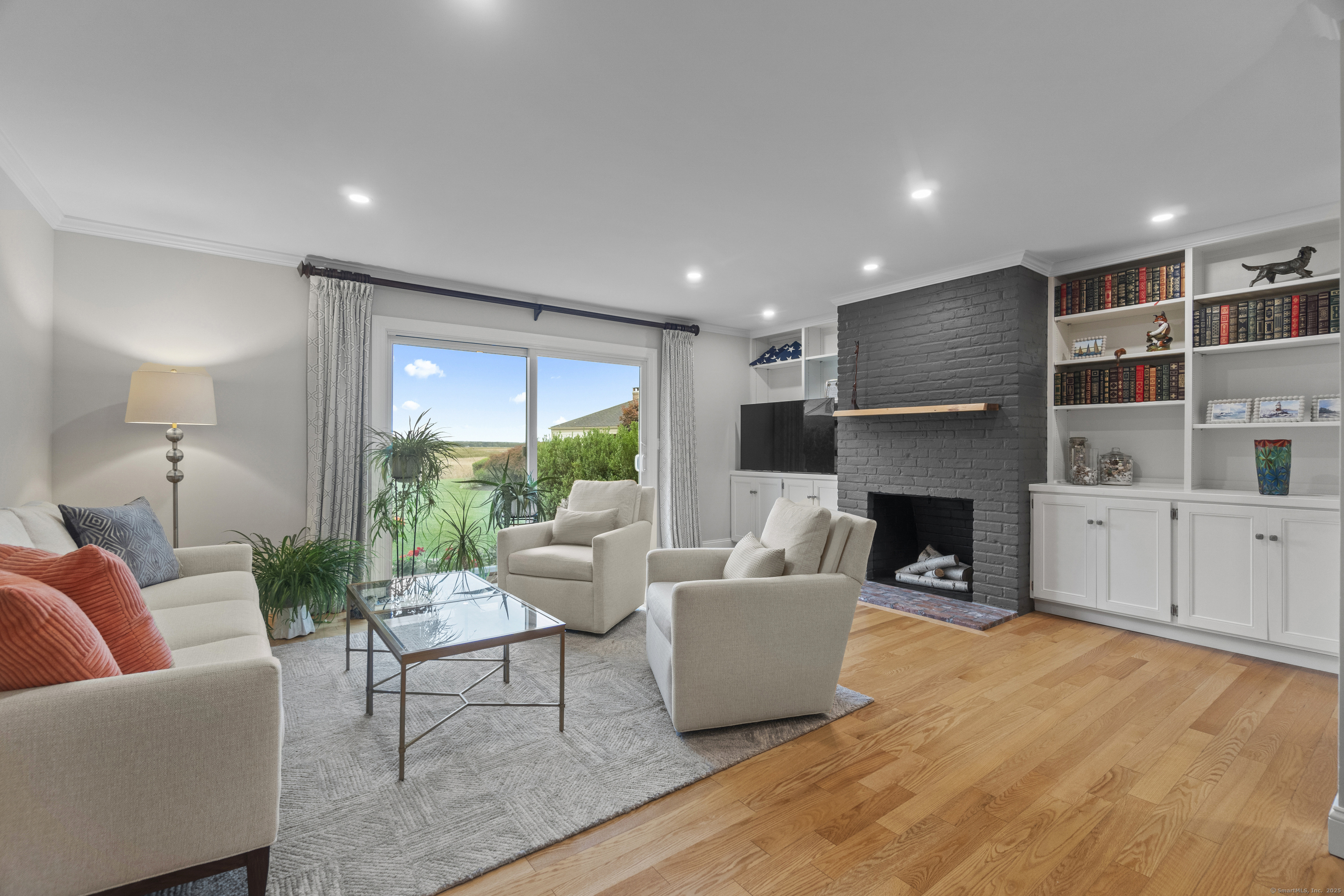 a living room with furniture fireplace and a large window
