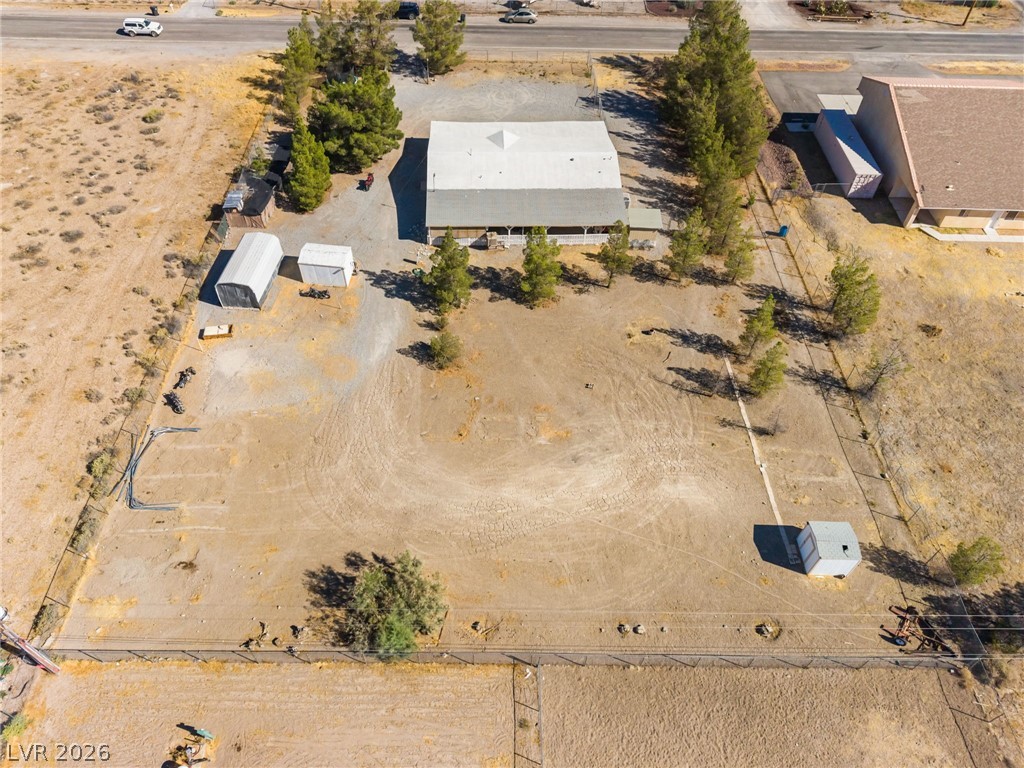 1551 West Wilson Road Pahrump, NV 89048 - Photo 61 of 68 An aerial perspective showcases the spacious lot, perimeter fencing, and detached outbuildings.