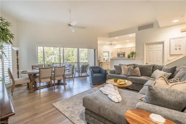 a living room with furniture wooden floor and a floor to ceiling window
