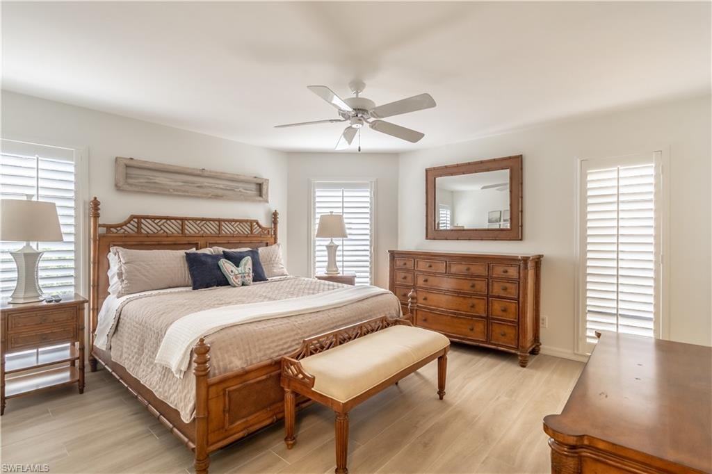 651 10th Avenue South, Unit C651 Naples, FL 34102 - Photo 11 of 32 a bedroom with a bed chandelier and a window