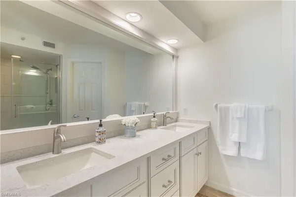 a bathroom with 2 sink tub and a mirror