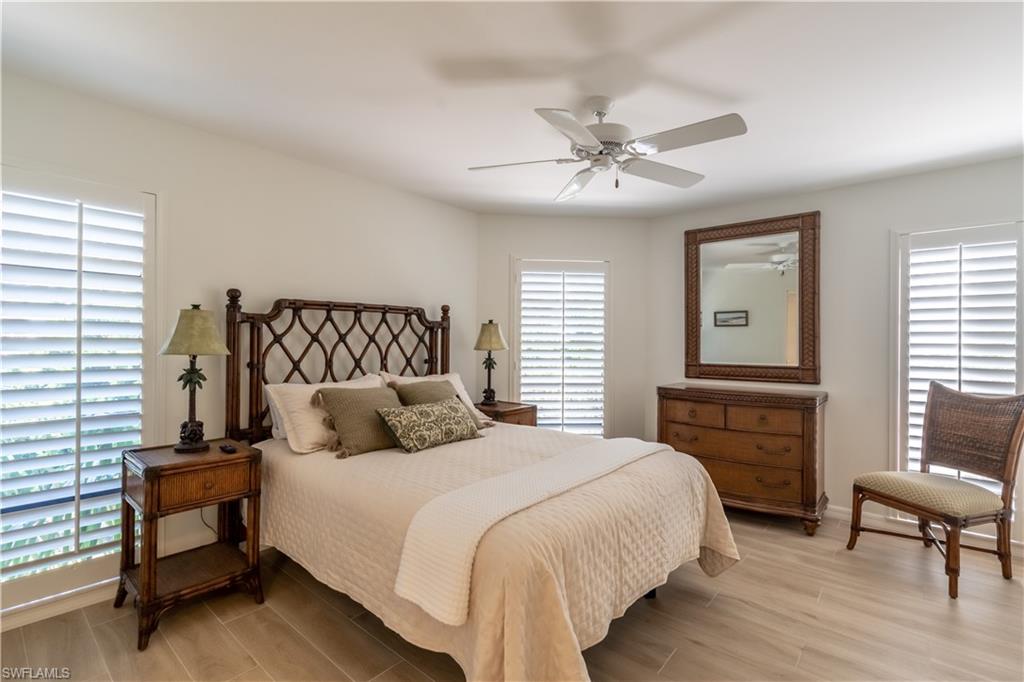 651 10th Avenue South, Unit C651 Naples, FL 34102 - Photo 18 of 32 a bedroom with a bed and a chandelier