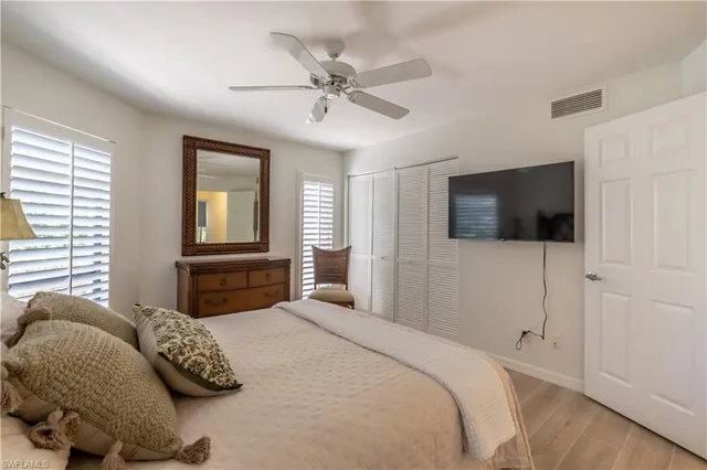 a bedroom with a bed a mirror on dresser and a window