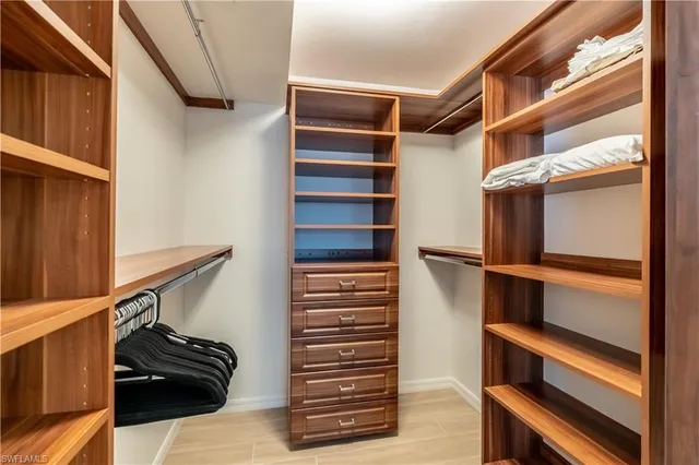a view of walk in closet with clothes and shoes