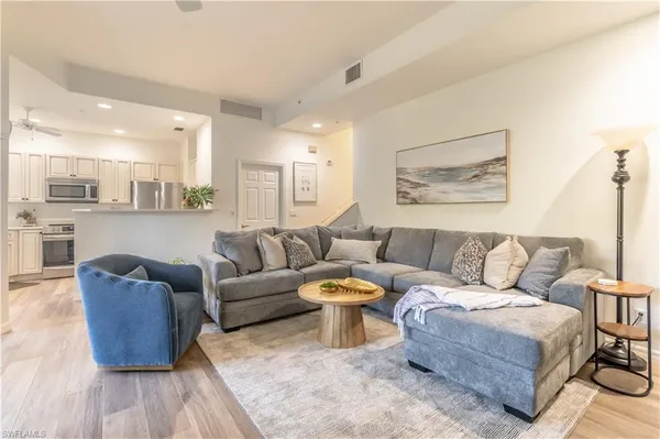 a living room with furniture a rug and a painting