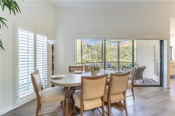 a dining room with furniture a chandelier and wooden floor
