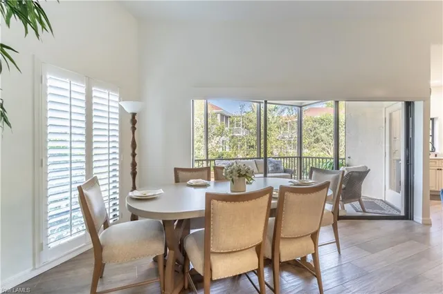 a dining room with furniture a chandelier and wooden floor