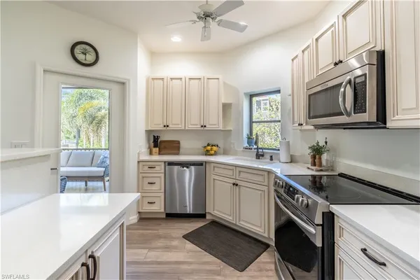 a kitchen with cabinets appliances a sink and a window