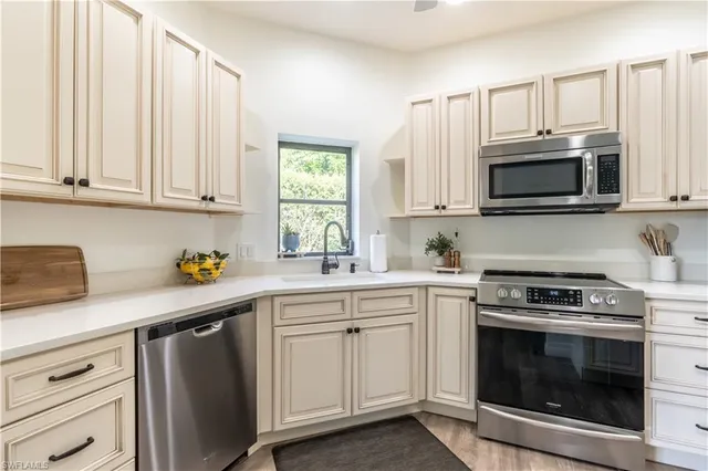 a kitchen with granite countertop white cabinets white stainless steel appliances and a sink