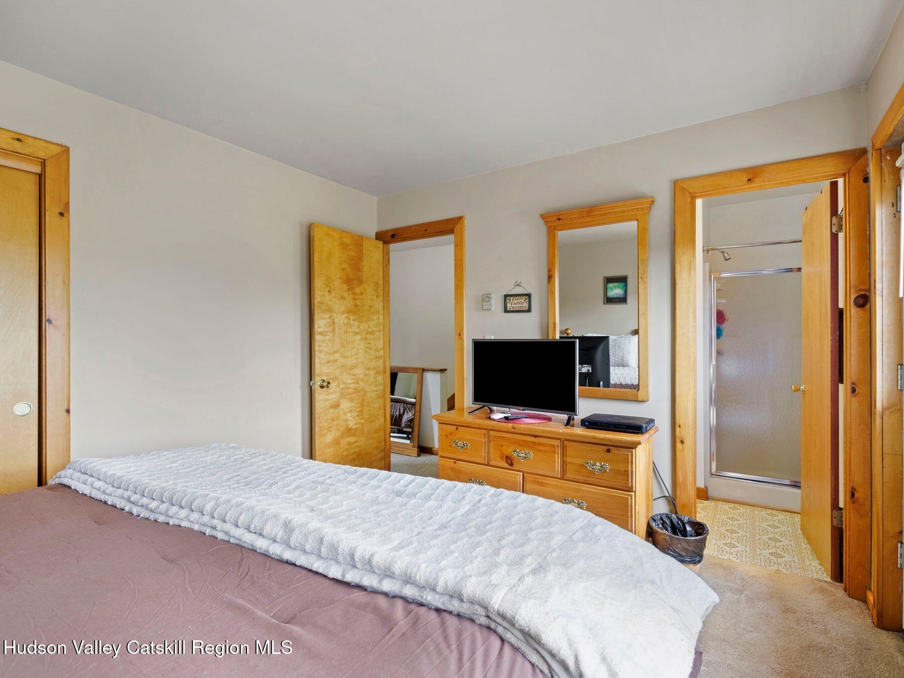 55 Windham Ridge Road, Unit 15H Windham, NY 12496 - Photo 18 of 34 a bedroom with a bed and flat screen tv