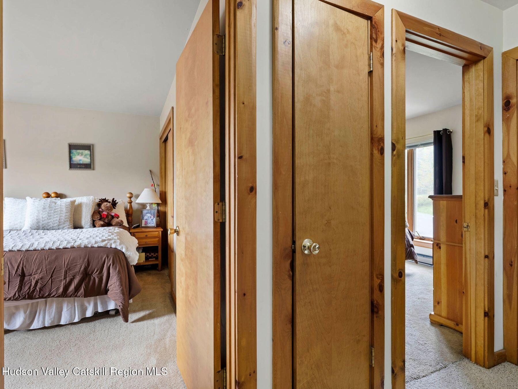 55 Windham Ridge Road, Unit 15H Windham, NY 12496 - Photo 20 of 34 a bedroom with a bed and a mirror
