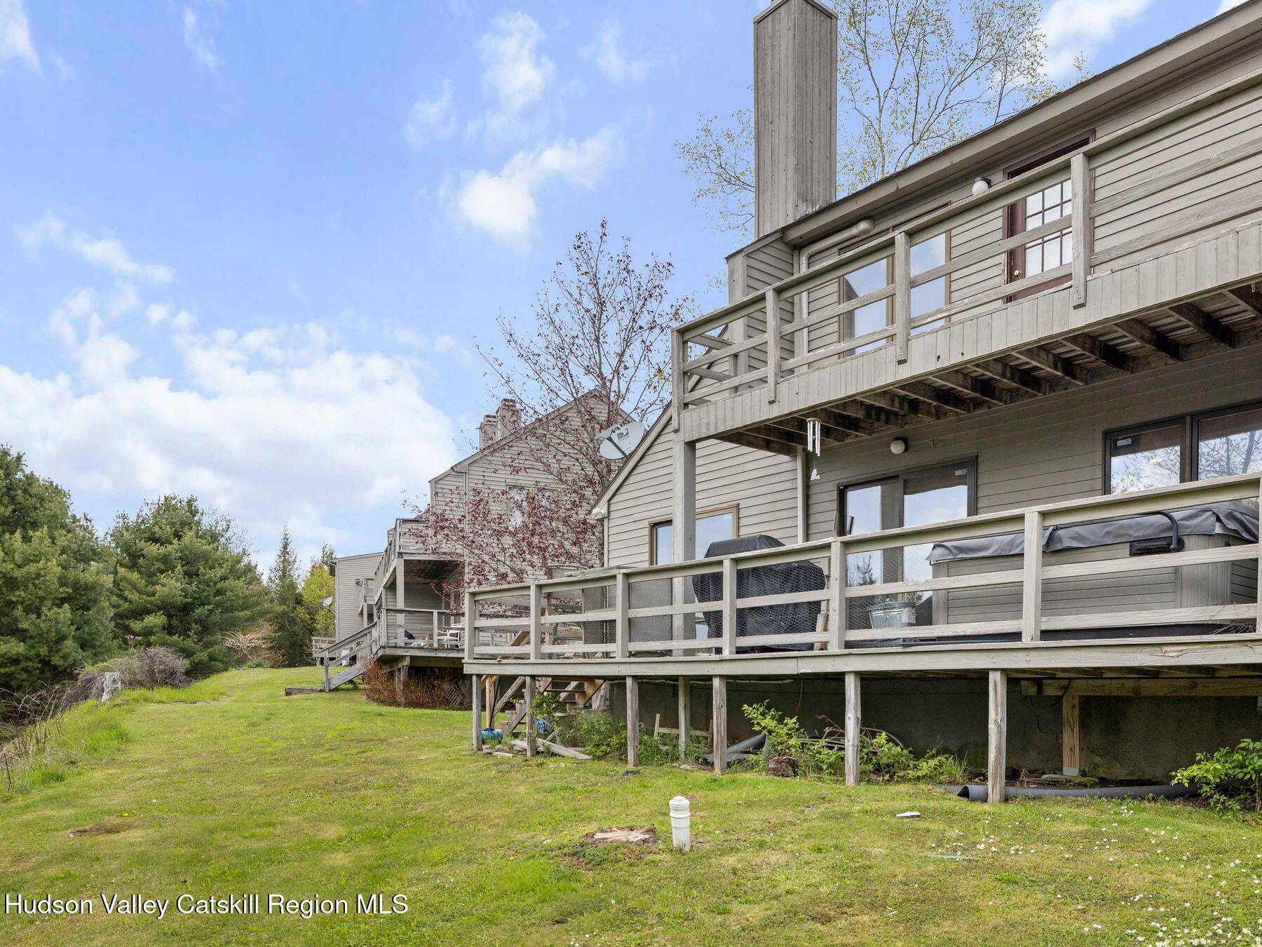 55 Windham Ridge Road, Unit 15H Windham, NY 12496 - Photo 28 of 34 a large building with a big yard and large trees