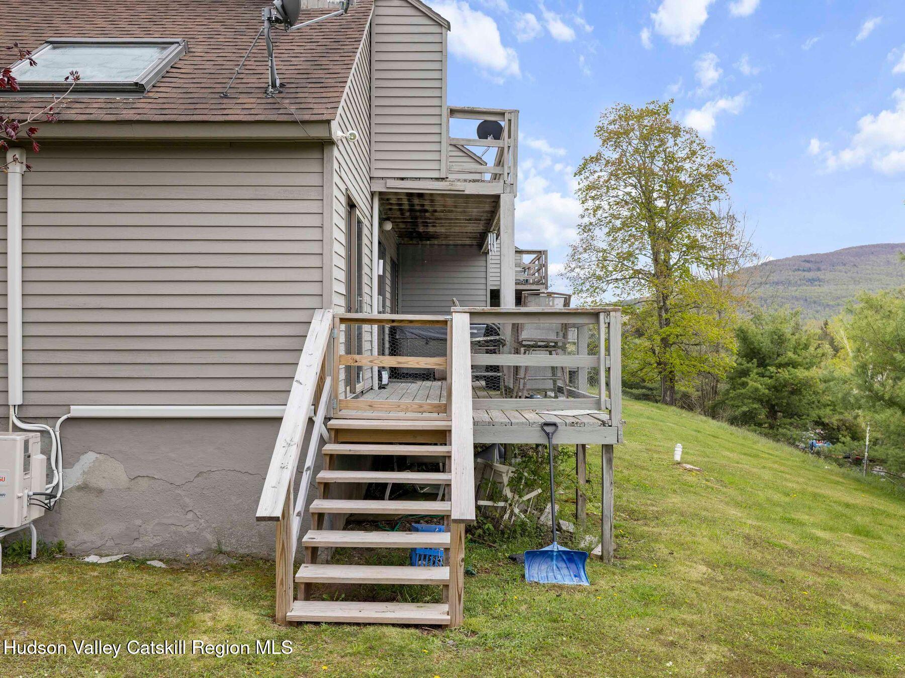 55 Windham Ridge Road, Unit 15H Windham, NY 12496 - Photo 29 of 34 a view of a patio with table and chairs with wooden floor and fence