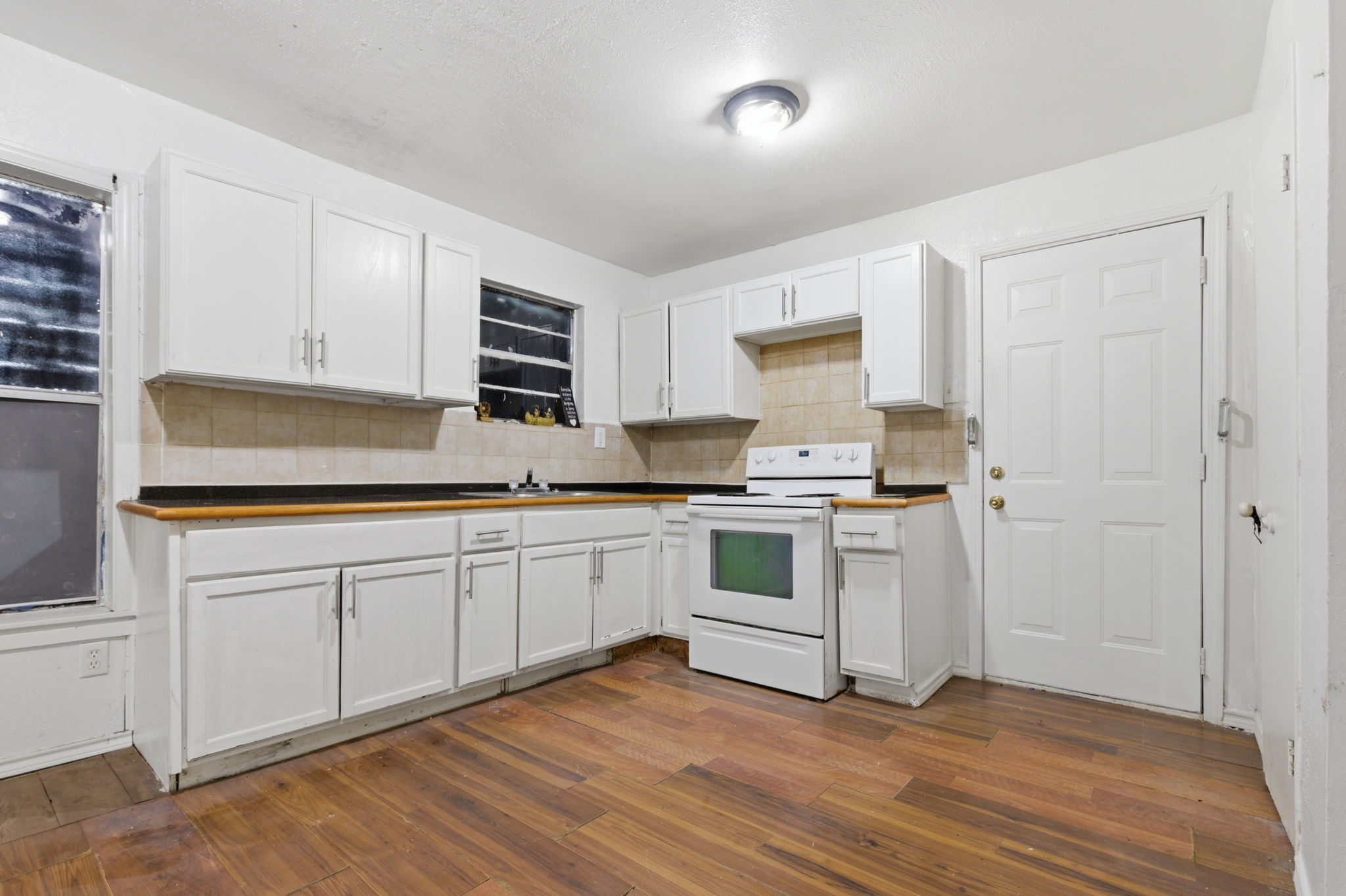 2423 Chamberlain Street Houston, TX 77093 - Photo 7 of 14 a kitchen with granite countertop white cabinets and white appliances