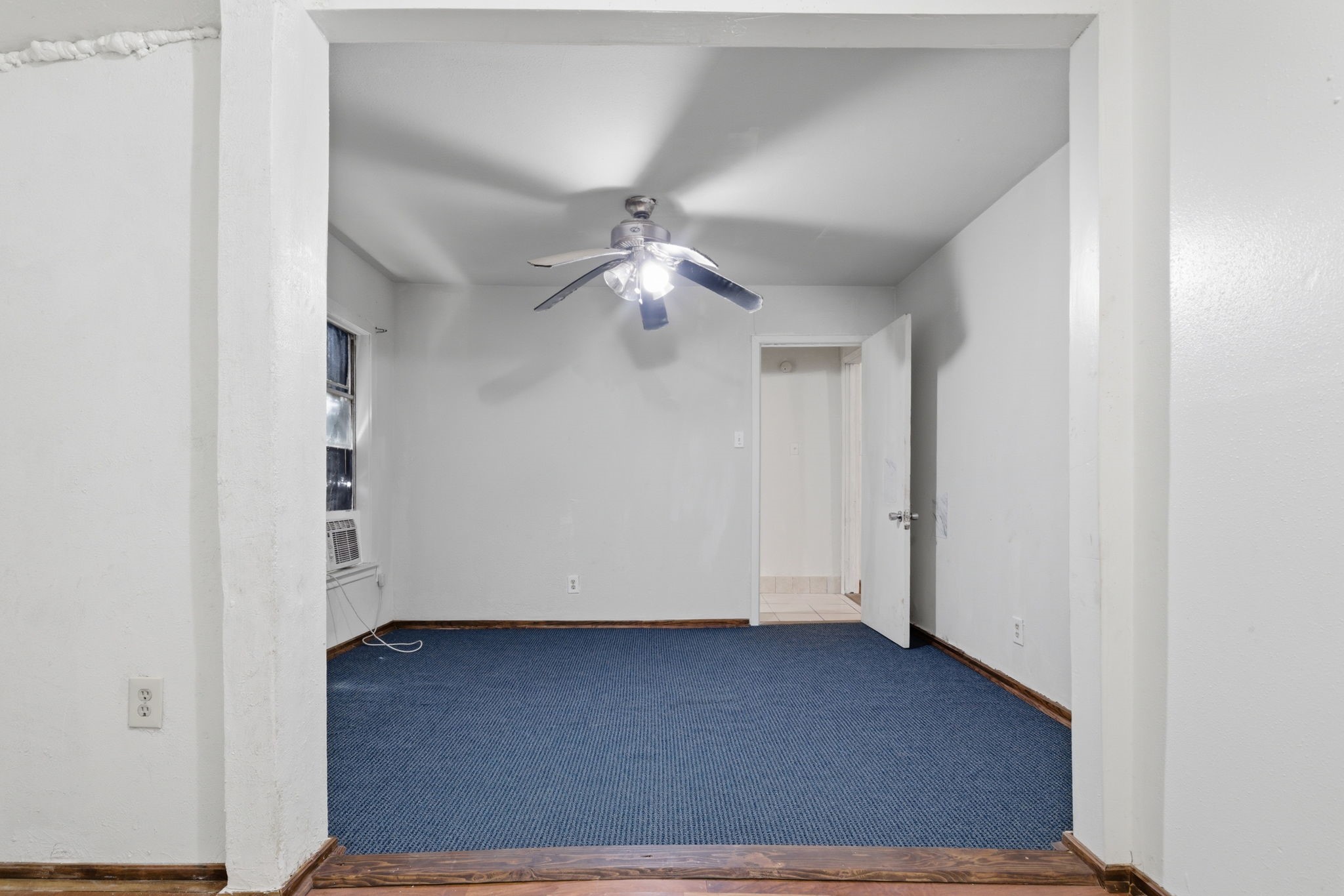 2423 Chamberlain Street Houston, TX 77093 - Photo 10 of 14 an empty room with a ceiling fan and wooden floor