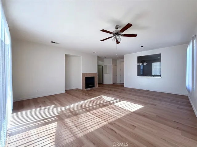 a view of empty room with wooden floor and window