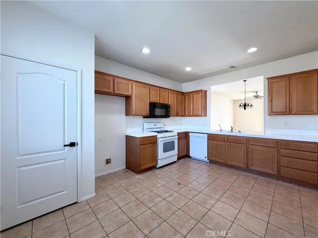 a large kitchen with stainless steel appliances lots of counter space and wooden cabinets